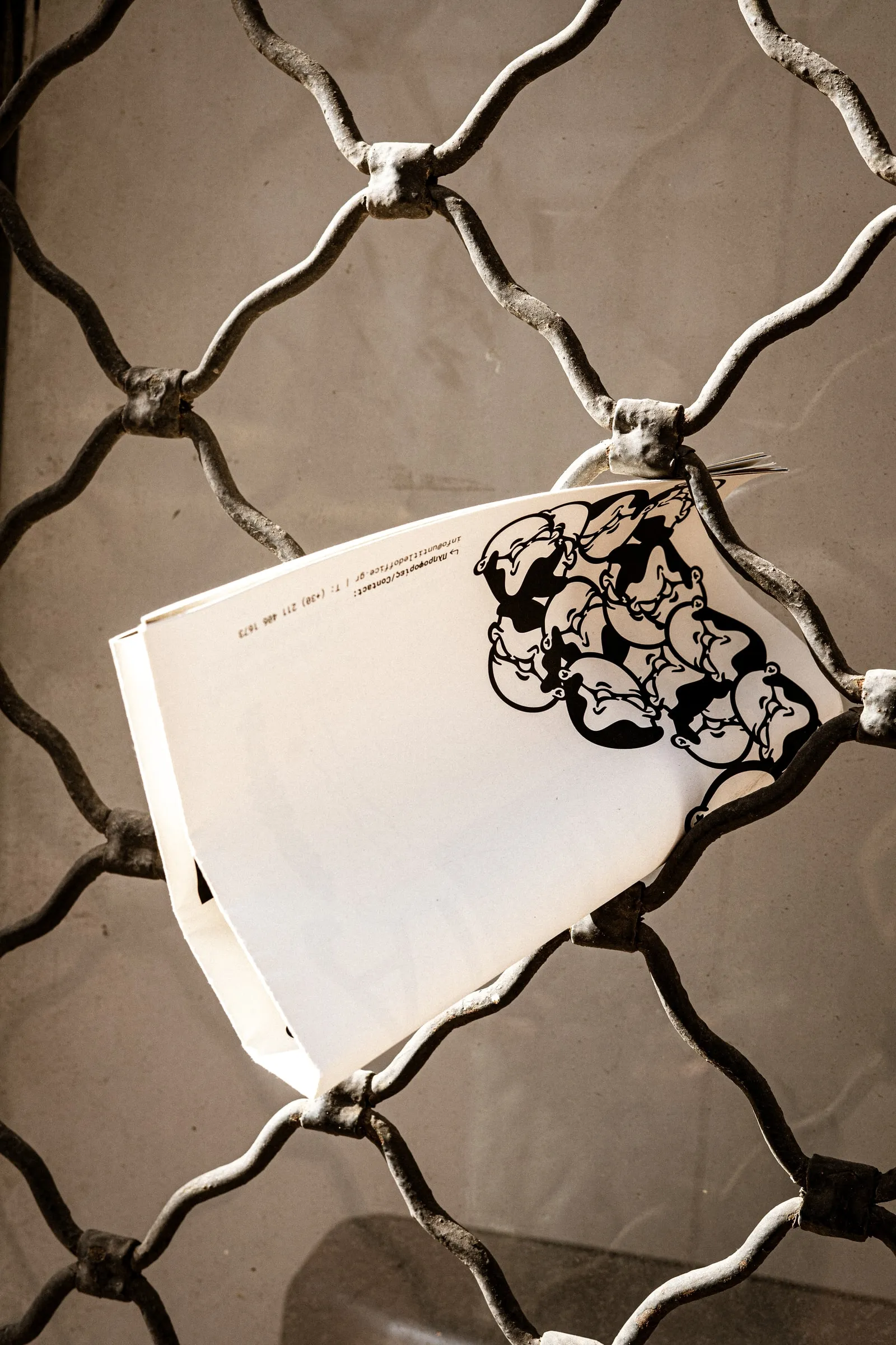 A magazine page caught in a metal security grille