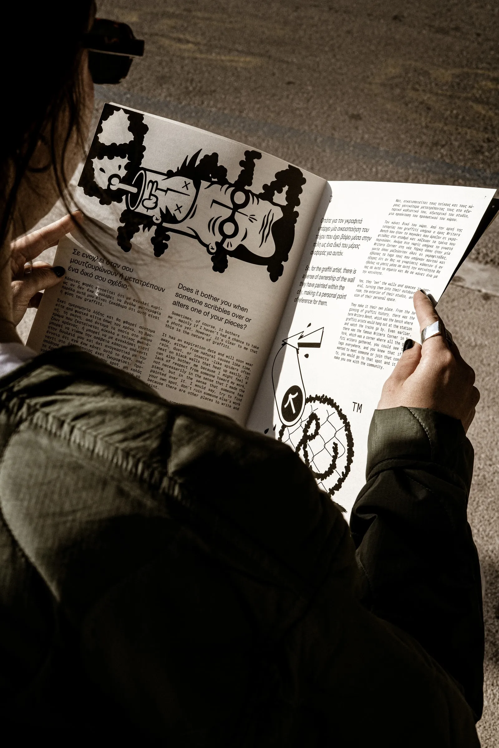 Close-up of hands holding the magazine open at an illustrated article
