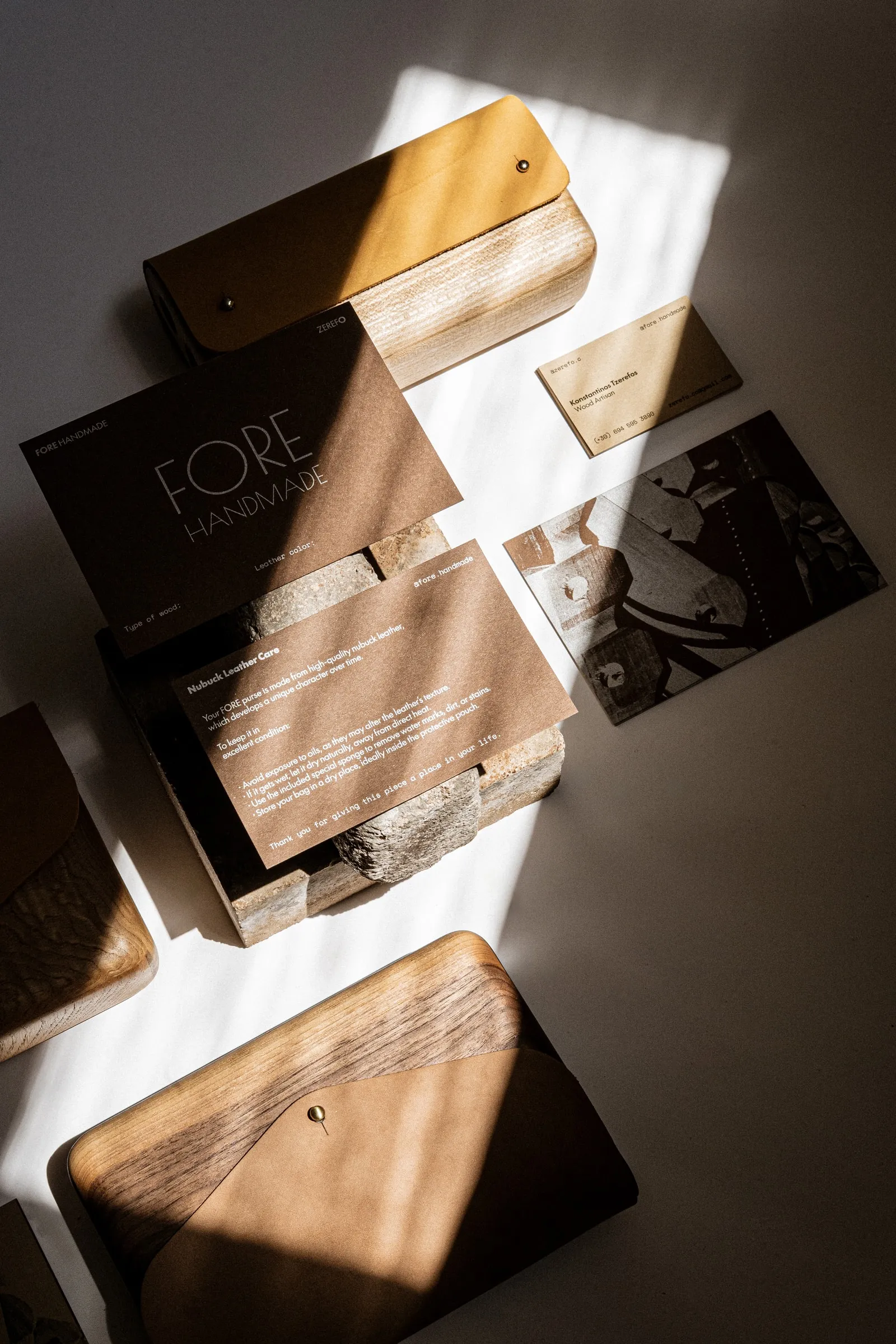 A FORE HANDMADE card and printed leaflets resting on a stone among the bags