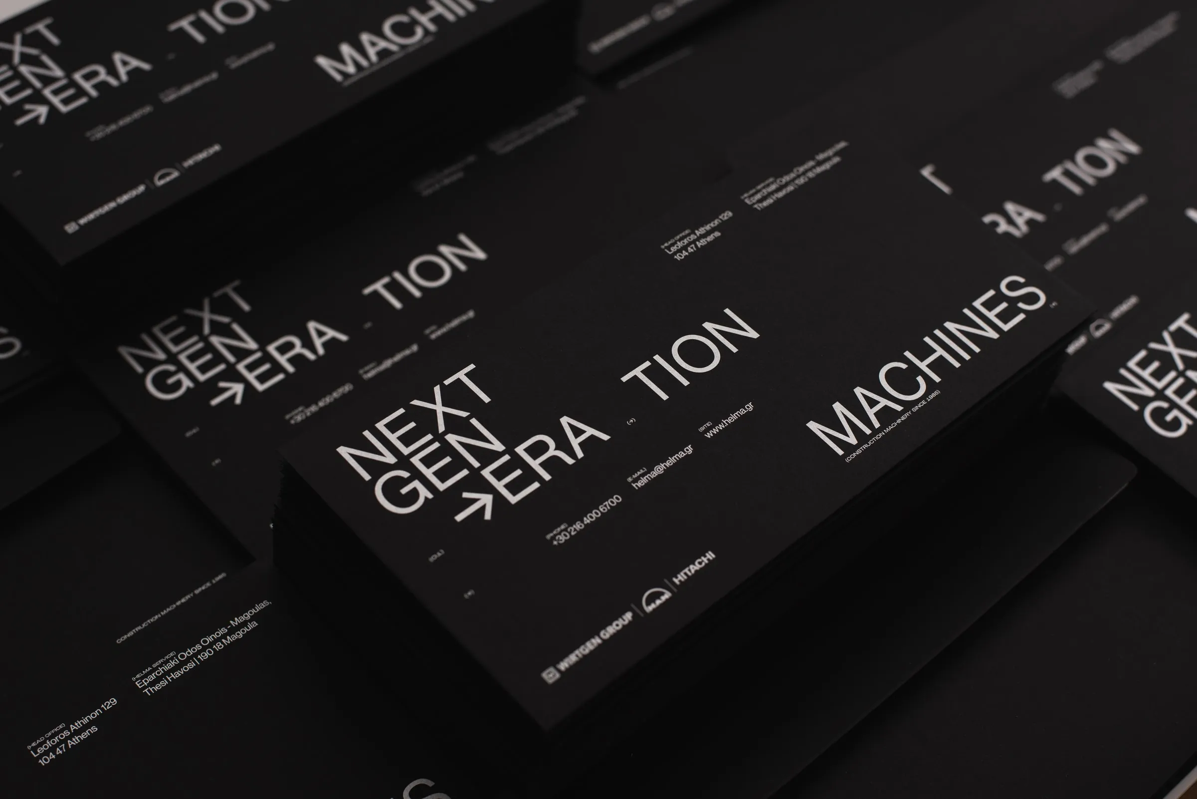 Rows of black Helma cards printed with NEXT GEN→ERA·TION MACHINES in white type