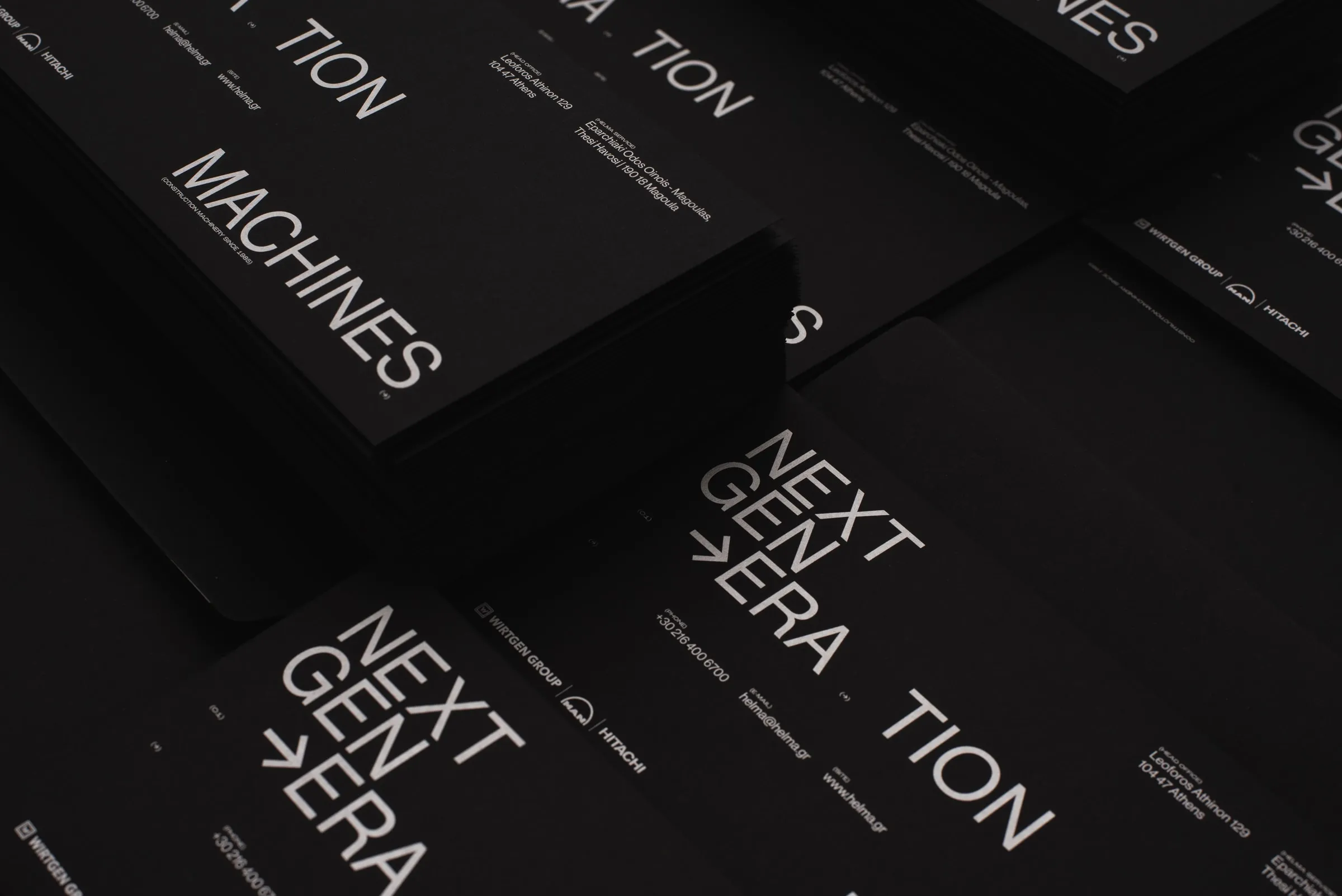 Close-up of stacked black Helma cards with white typography at an angle