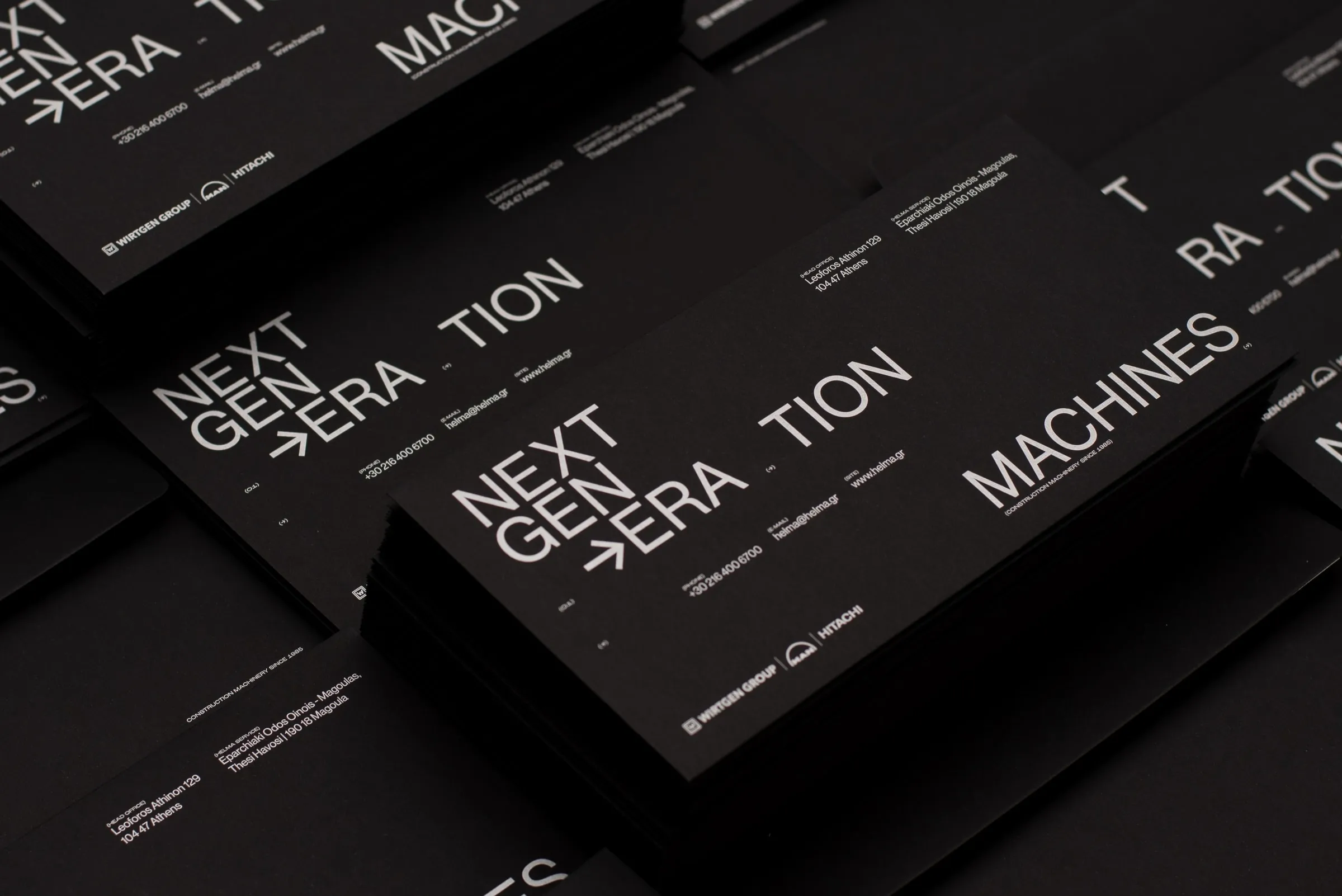 Stacks of black Helma cards with white NEXT GEN→ERA·TION typography
