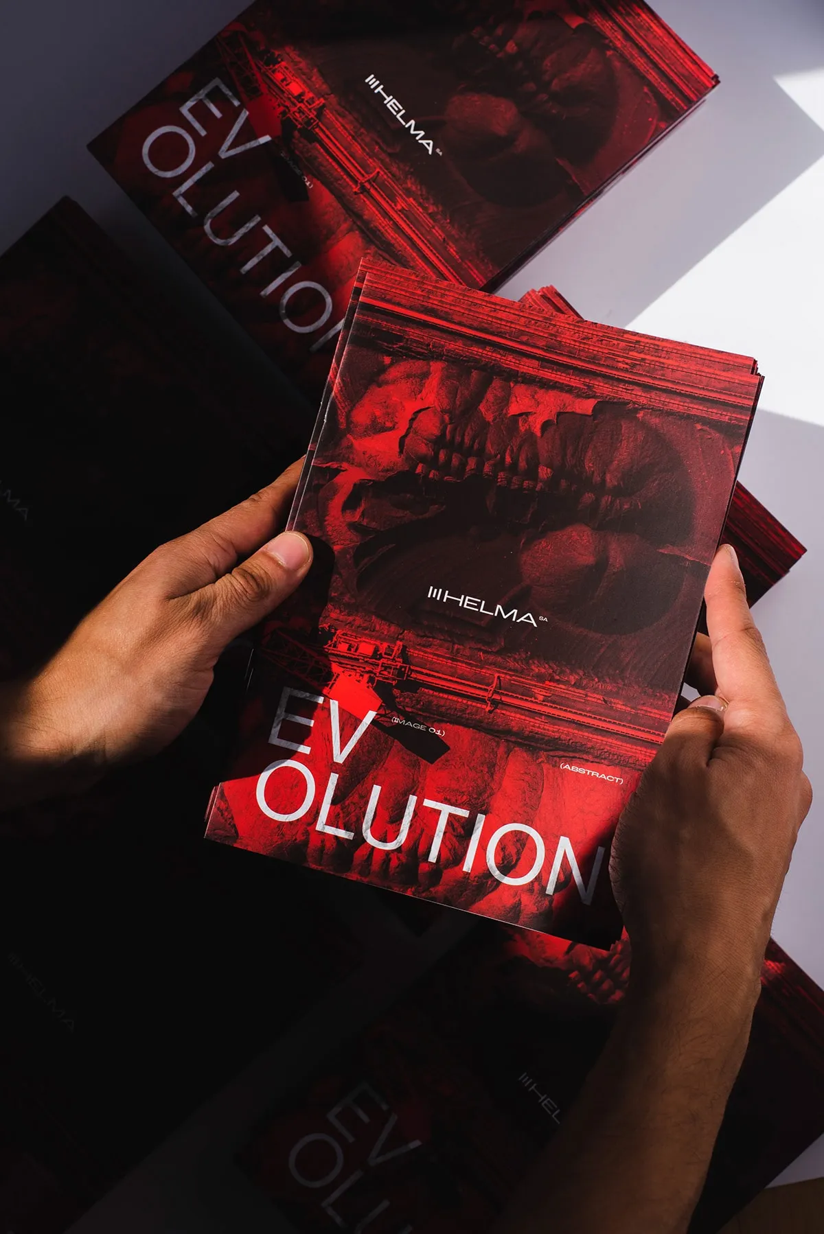 Hands holding a red Helma brochure titled EVOLUTION