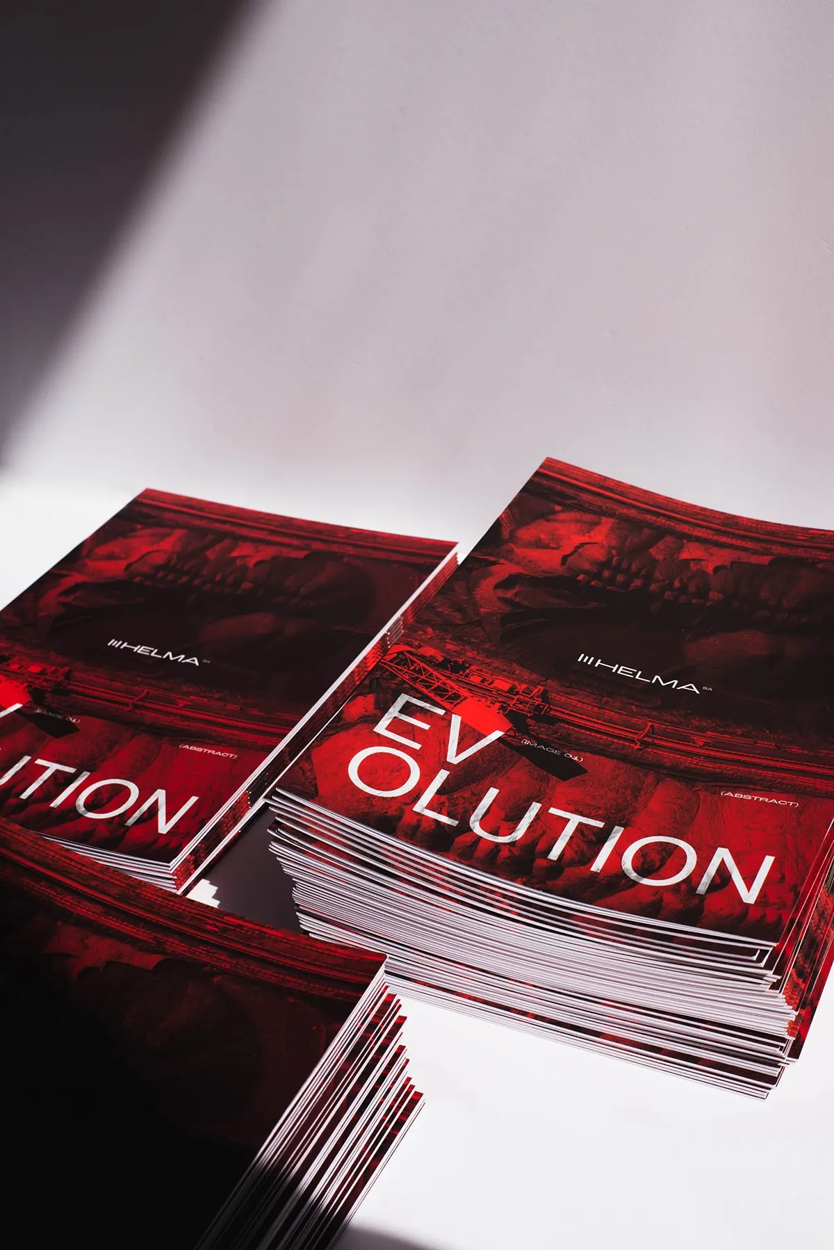 Stacks of red EVOLUTION brochures in raking light