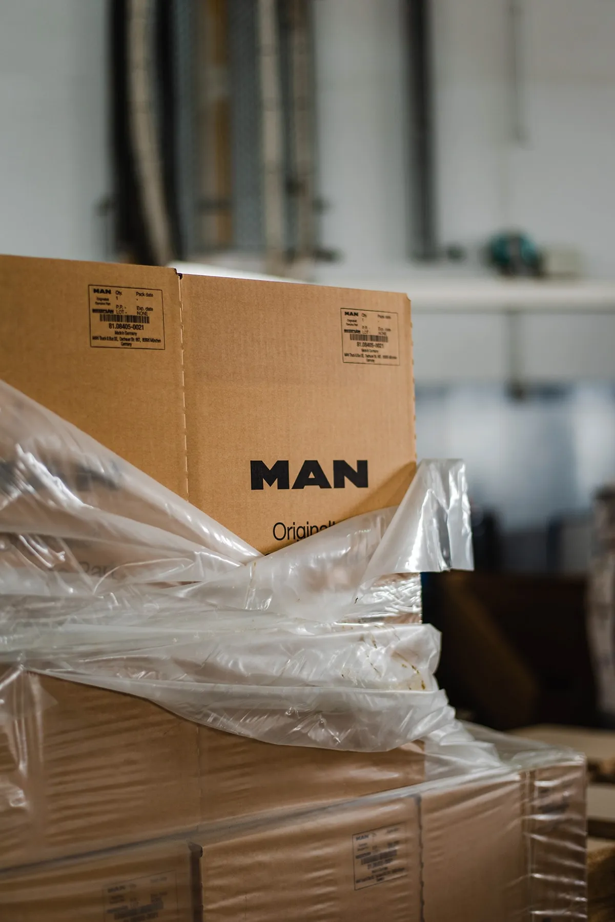 MAN parts boxes wrapped in plastic on a warehouse shelf