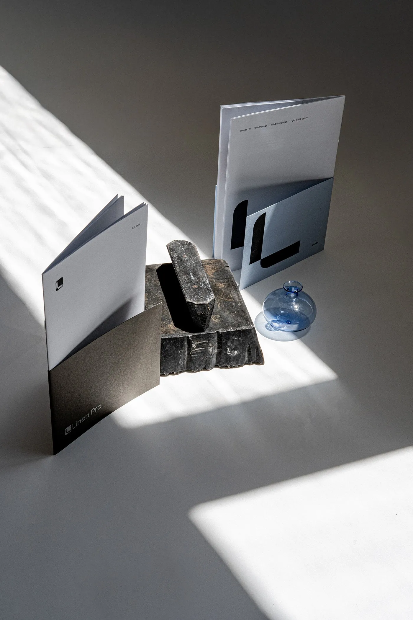 Folded leaflets standing around a dark brick beside a blue glass globe