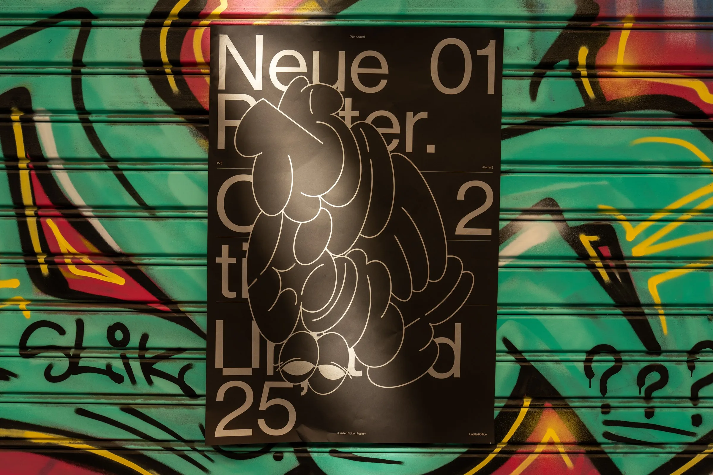 The poster on a green and red graffiti shutter