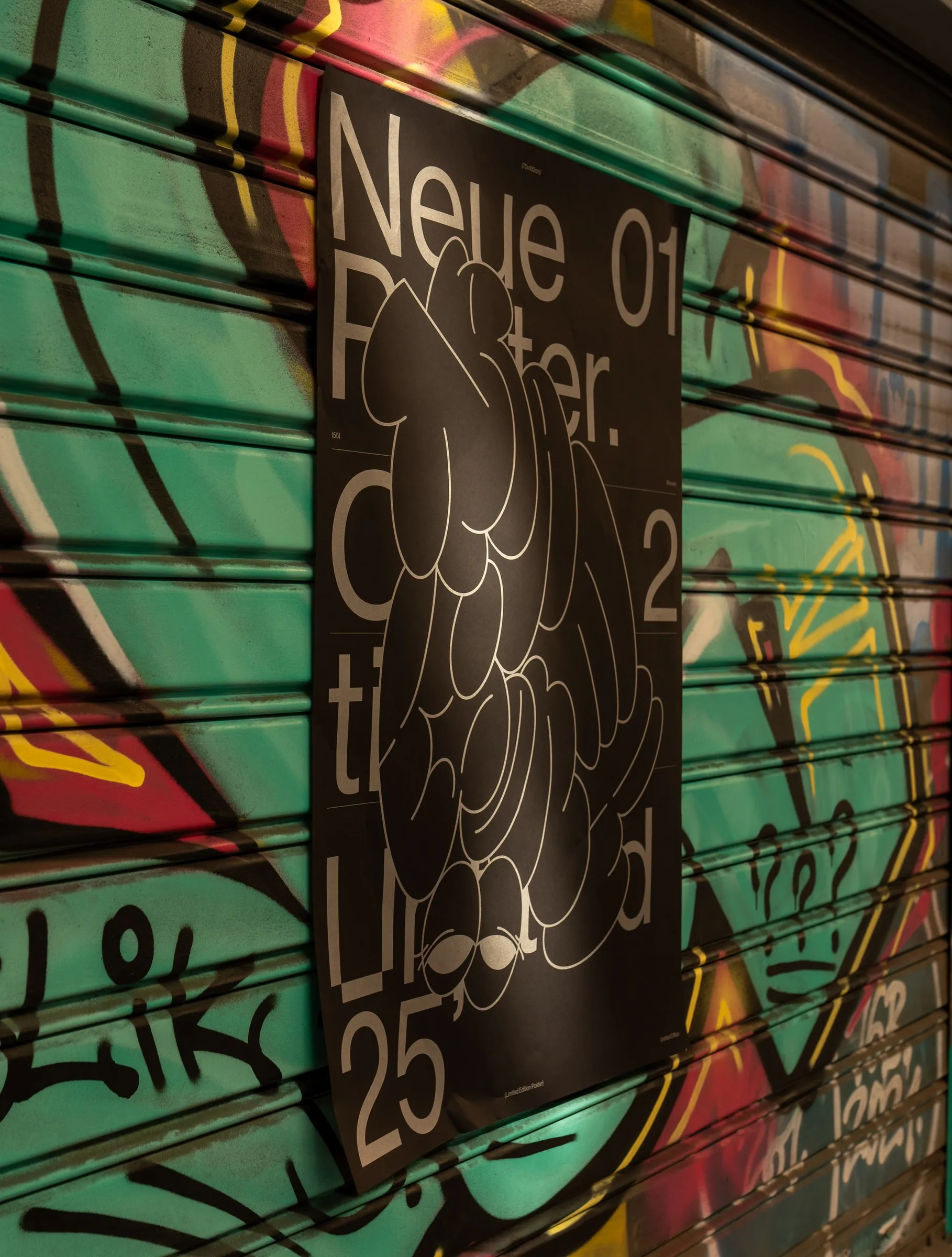 The poster on a green graffiti-covered shutter