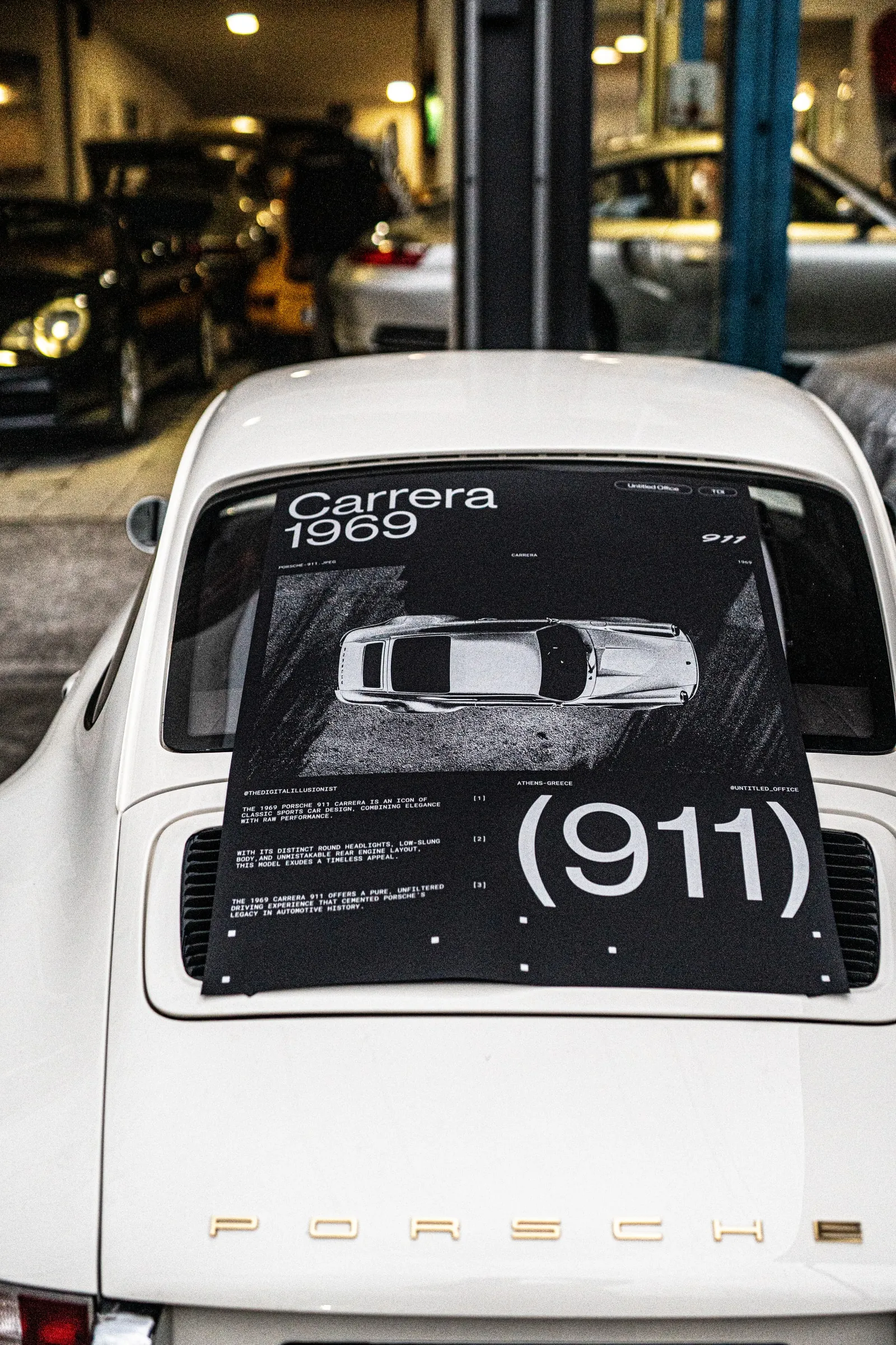 The poster on the rear engine lid of a white Porsche 911 in a workshop