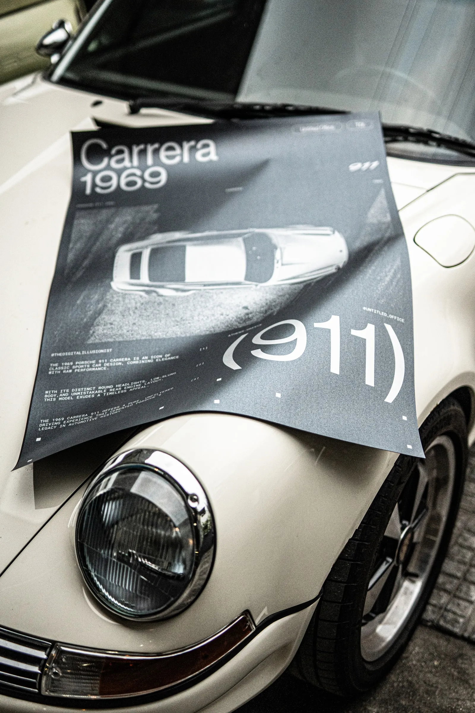 The poster draped over the front wing of a white Porsche 911
