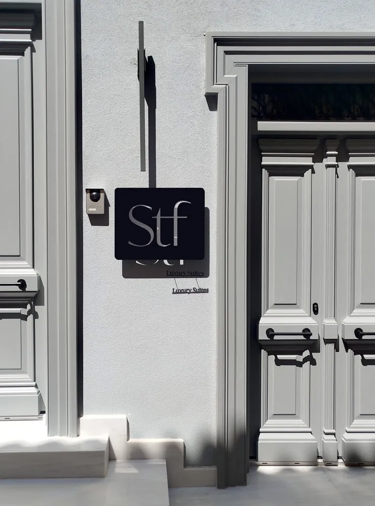 The black STF sign beside a neoclassical doorway, with Luxury Suites lettering below it on the white wall