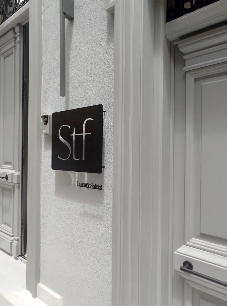 The STF sign seen at an angle, its die-cut letters and small Luxury Suites lettering casting shadows on the wall