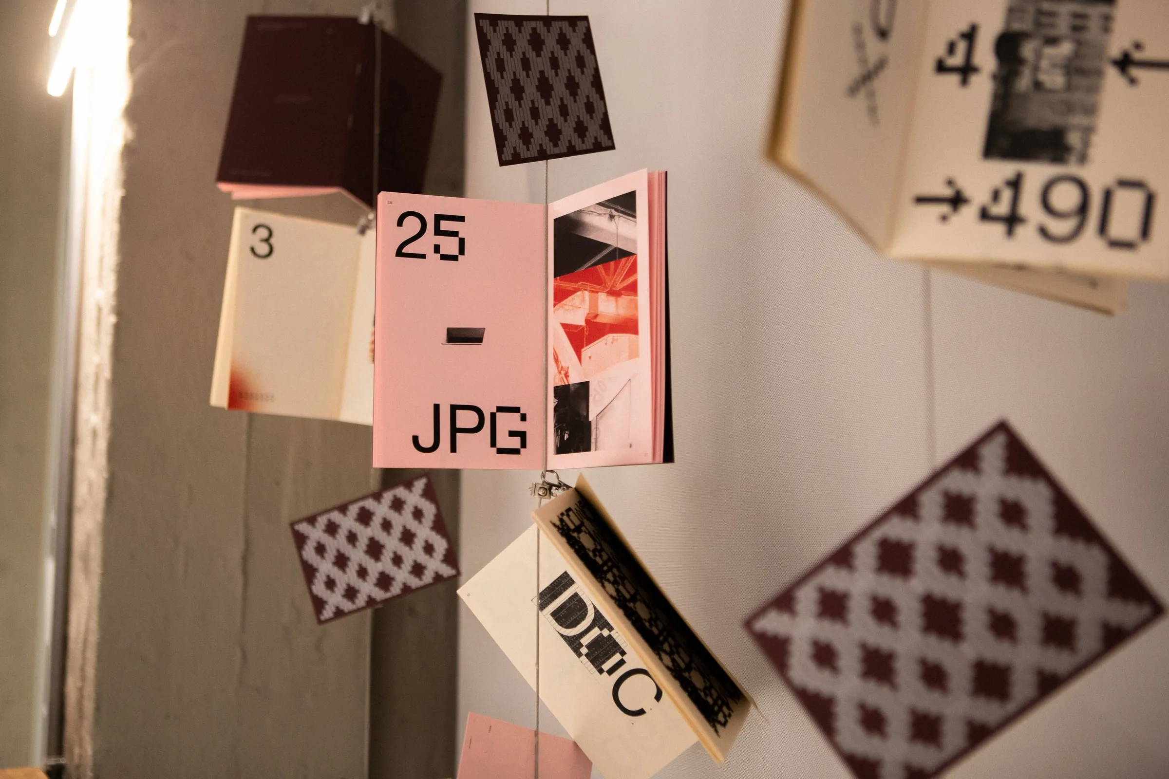 Zine pages hung in the air as an exhibition installation