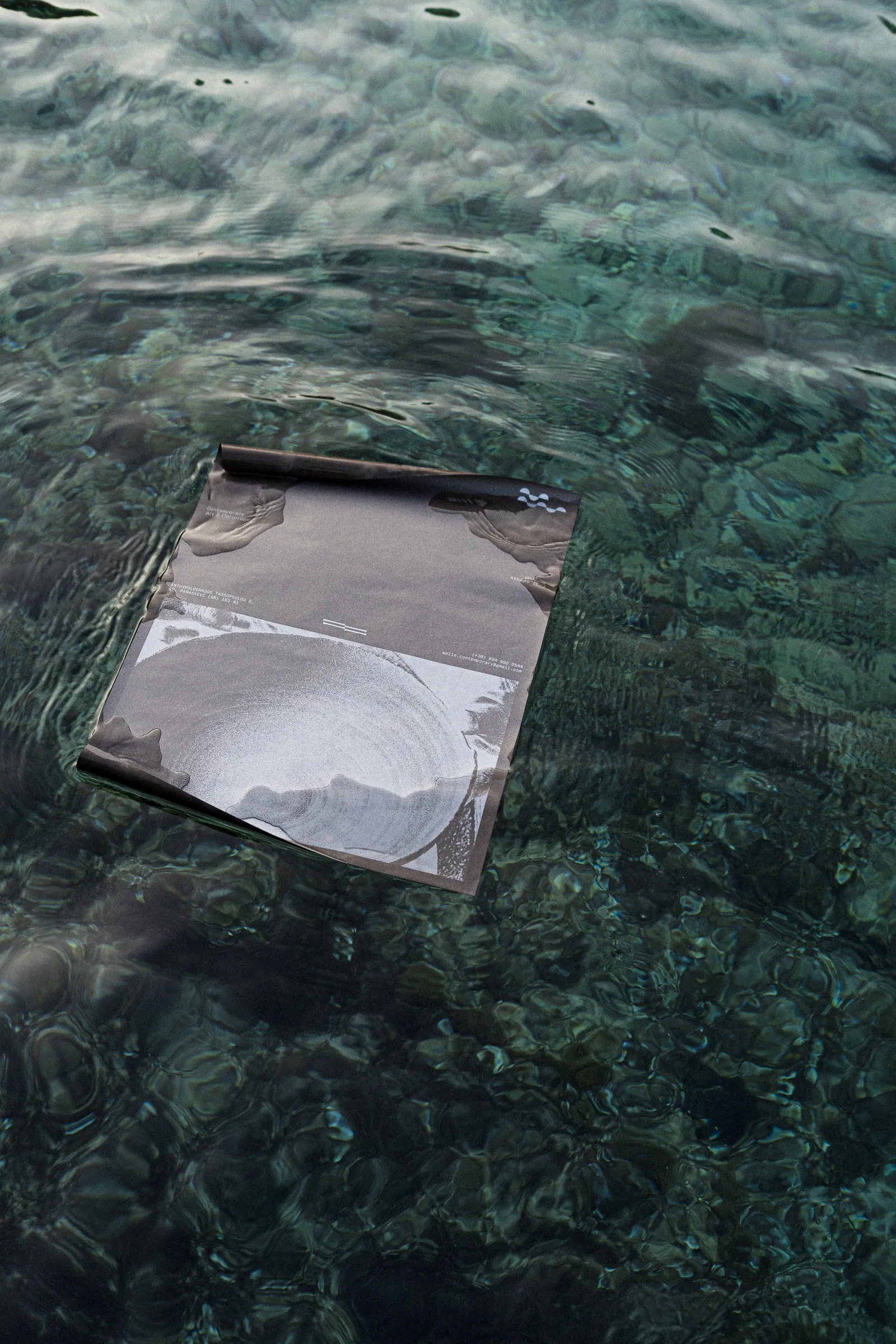 A Welle poster with a ceramic bowl print, floating on clear green water